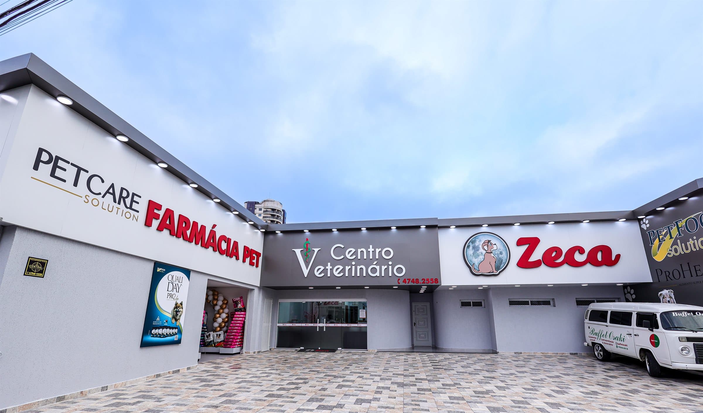 Fachada do Centro Veterinário Zeca Pet, com farmácia pet à esquerda e amplo pátio de entrada